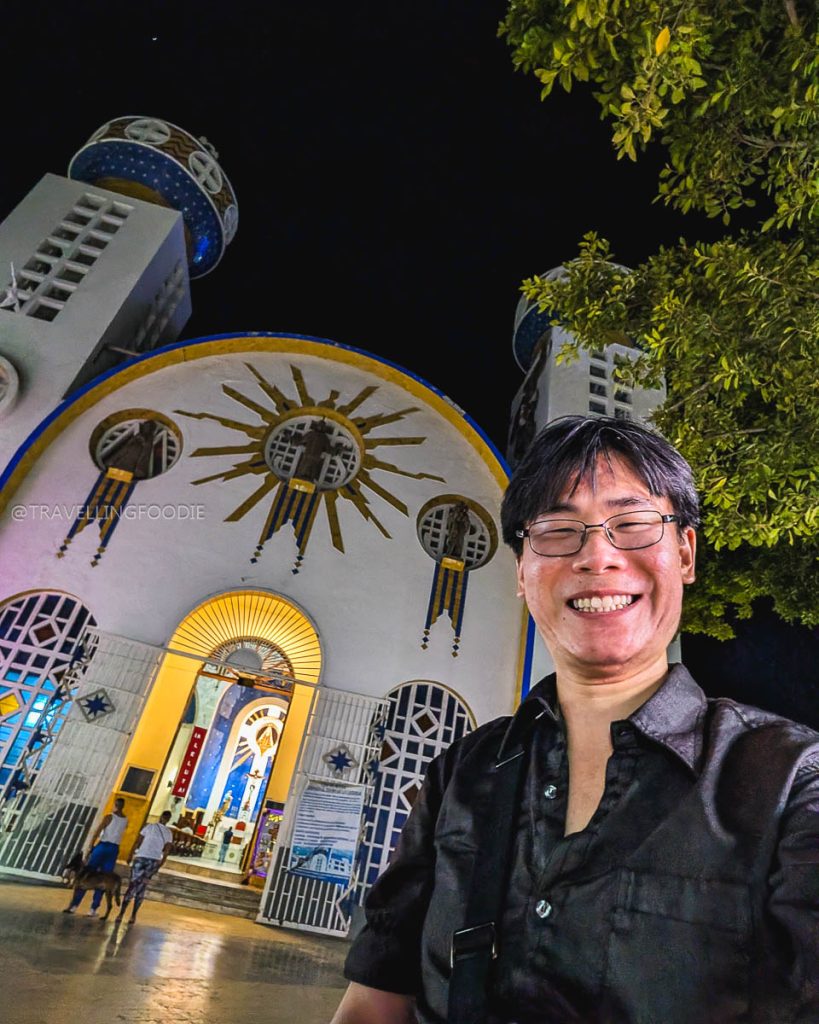 Raymond Cua smiling at night outside the Acapulco Cathedral, showcasing its unique Moorish and Byzantine architecture.