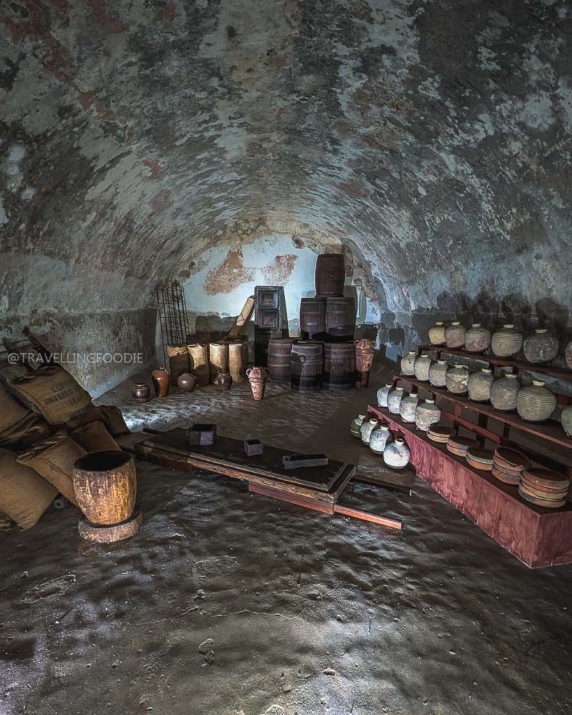 Historic storage room with wooden barrels and clay pots inside the Acapulco Historical Museum of Fort San Diego.