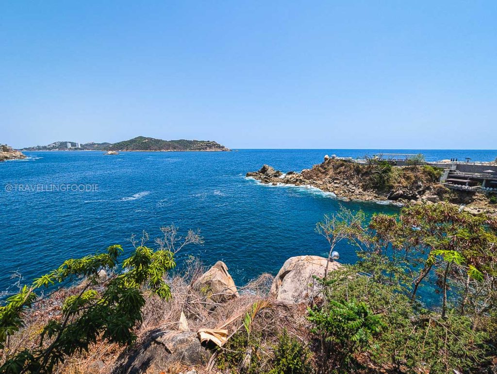 Stunning view of the rocky coastline and blue Pacific Ocean from the elevated Punta Sirena restaurant in Acapulco.