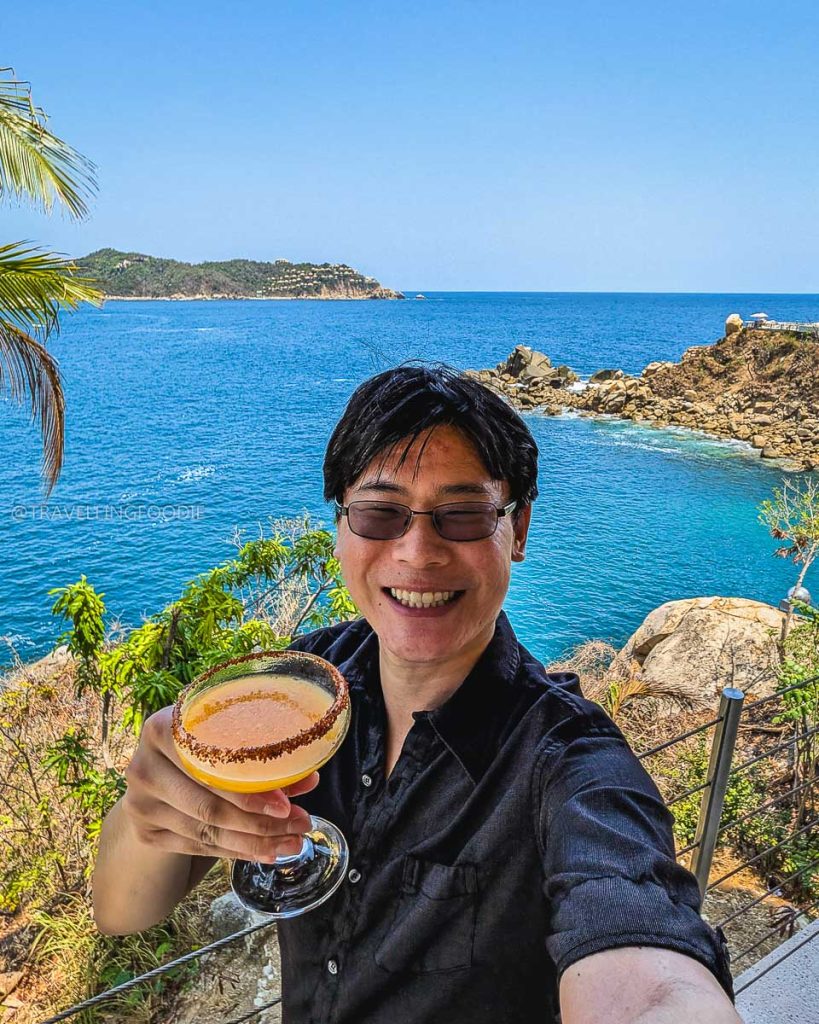 Travelling Foodie Raymond Cua enjoying a refreshing cocktail with amazing ocean views at Punta Sirena in Acapulco.