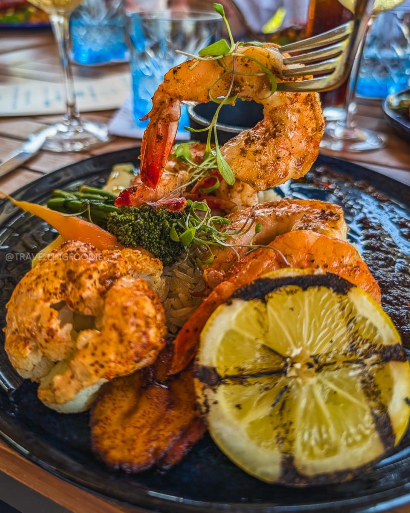 Close up of delicious grilled shrimp and roasted vegetables at Punta Sirena, highlighting the amazing local food scene in Acapulco.