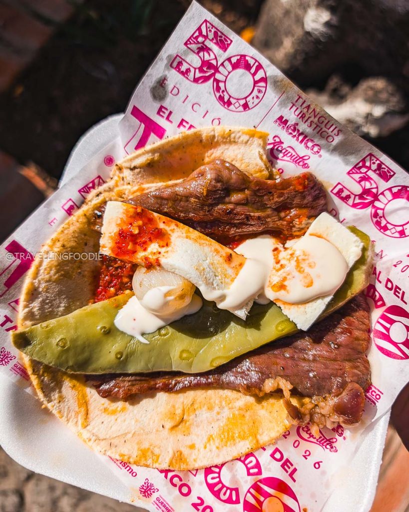 Delicious regional taco with meat, nopal, and cheese served on Tianguis Turistico paper at El Gran Taco in Taxco.