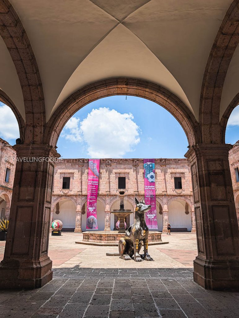 A bronze dog statue inside the gorgeous colonial arched courtyard of the Clavijero Cultural Center in Morelia.