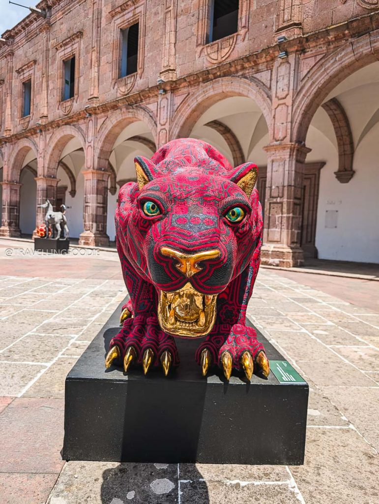 Vibrant beaded jaguar art sculpture exhibited at the historic Clavijero Cultural Center during a Michoacan trip.