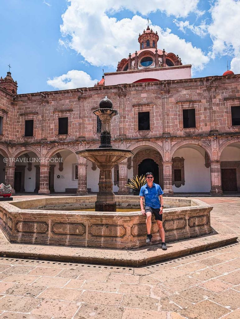 Travelling Foodie Raymond Cua by a historic colonial courtyard fountain in Clavijero Cultural Center during a 3 days in Michoacan road trip.