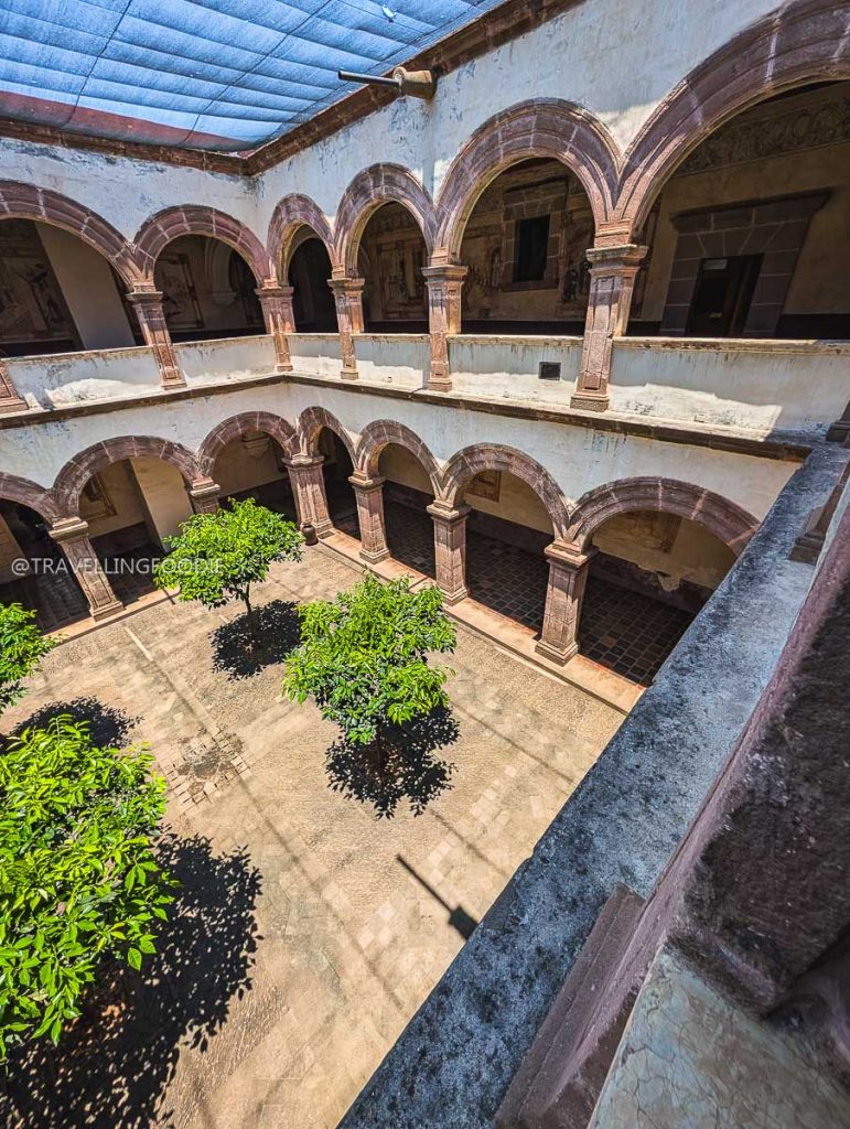 Stunning aerial view of a historic colonial courtyard with pink stone arches during a Michoacan trip.