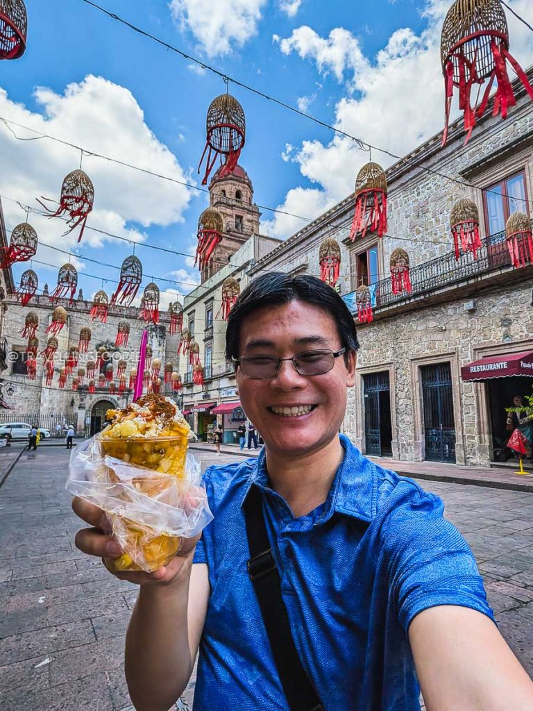 Travelling Foodie Raymond Cua holding a refreshing Gaspacho fruit snack while exploring fun things to do in Morelia.