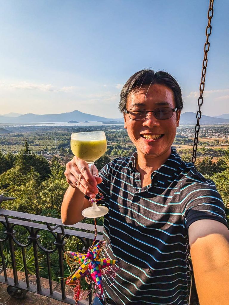 Travelling Foodie Raymond Cua enjoying a refreshing drink with a scenic view of Lake Patzcuaro on our Michoacan road trip.