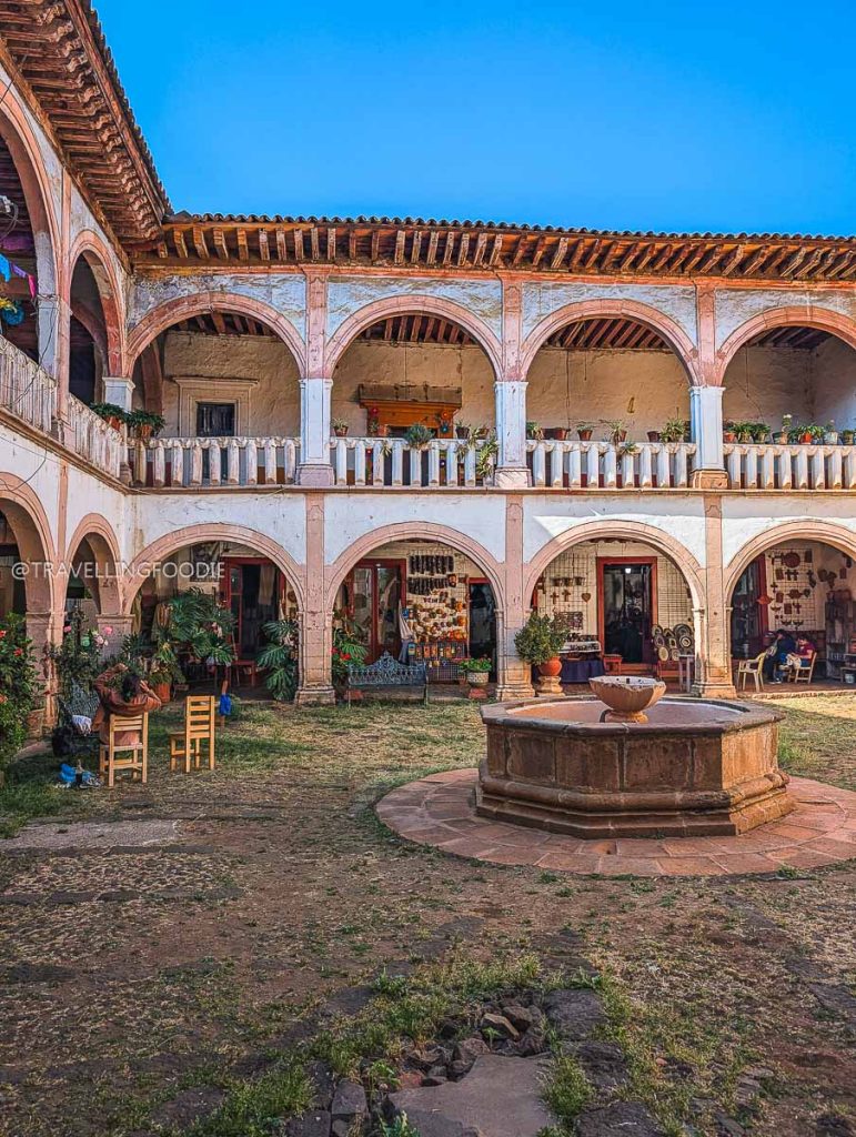 A peaceful colonial courtyard with a stone fountain, exploring the top things to do in Patzcuaro Michoacan.