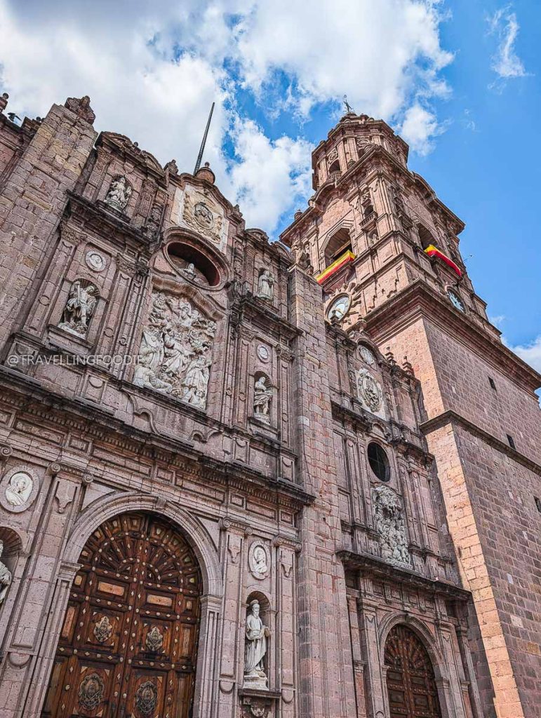Low angle view of the detailed stone facade and tower of Morelia Cathedral, a top Michoacan activity.