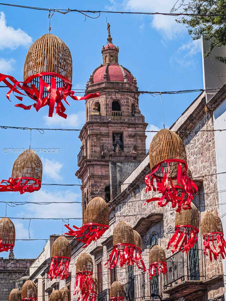 Beautiful hanging basket decorations and colonial church tower to admire on your Michoacan road trip.