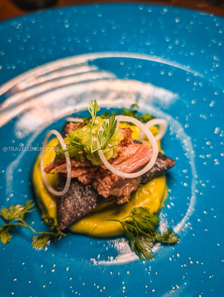 Delicious bean tetelas with pork and avocado puree, a top dish to try on your Michoacan itinerary.