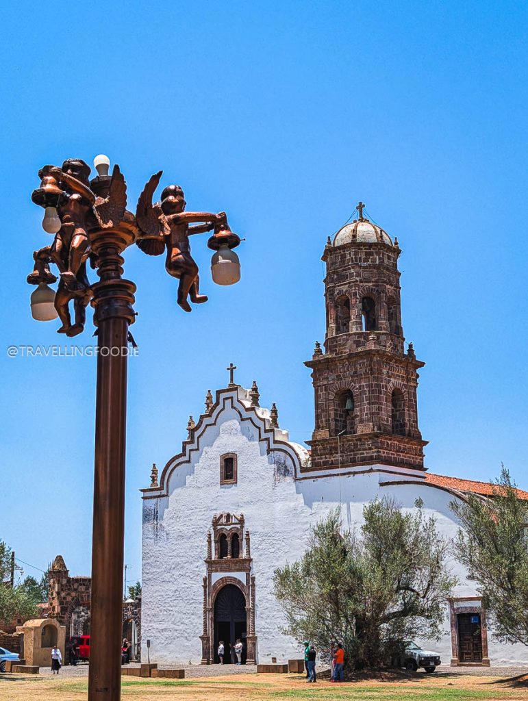 Angelic bronze street lamp by a stunning colonial church, a scenic stop during a 3 day trip in Michoacan.
