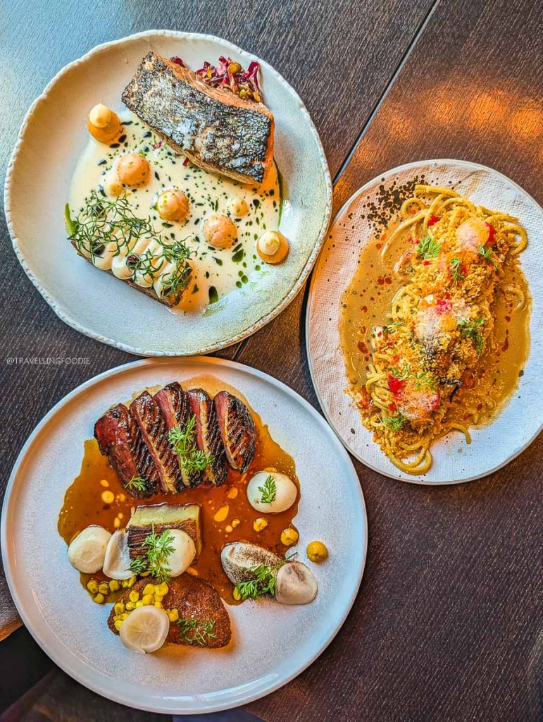 Main courses of salmon, duck breast, and spaghetti served at Bar Lupulus Ottawa.