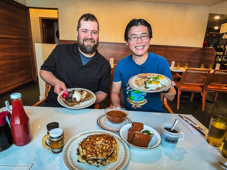 Holding plates of delicious breakfast food at Dukes, a fantastic Ottawa restaurant.