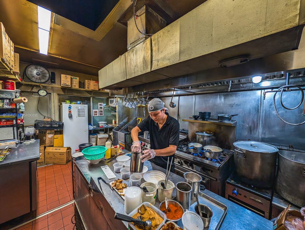 A chef preparing authentic culinary dishes inside the kitchen at Koichi Ramen Ottawa.
