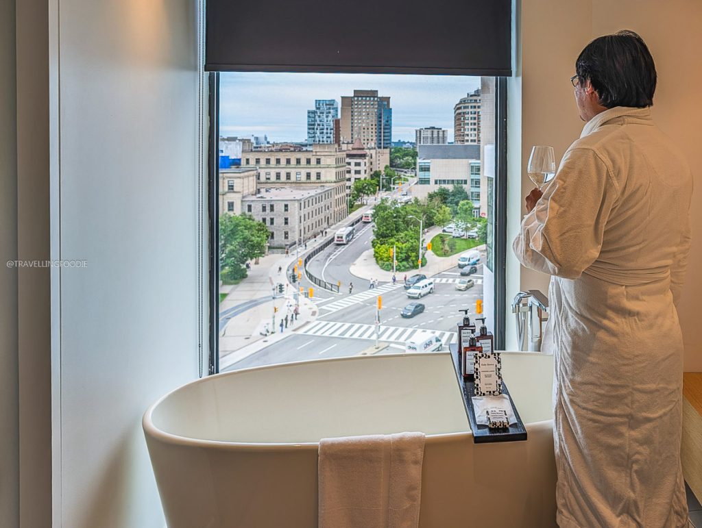 Travelling Foodie standing by the luxurious soaking tub admiring the city view at Le Germain Ottawa.
