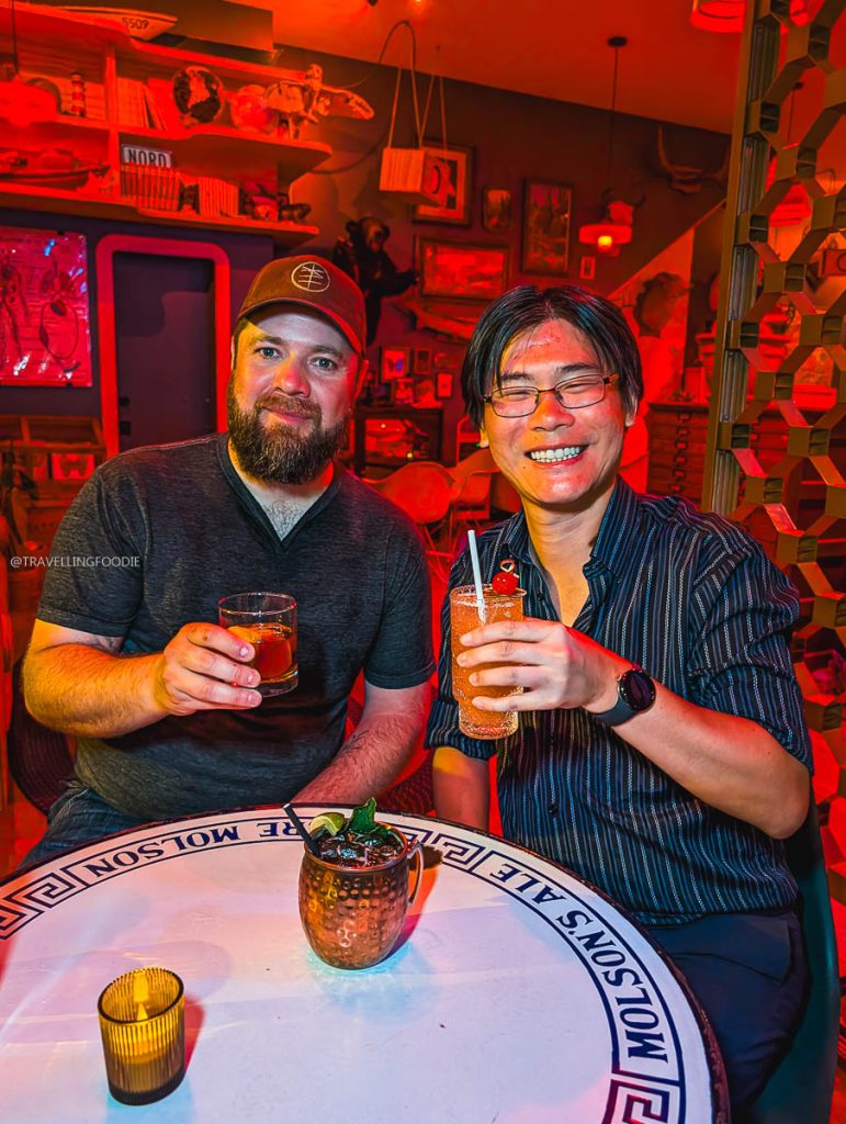 Travelling Foodie and Chef Justin Champagne-Lagarde holding drinks at a unique Ottawa bar.