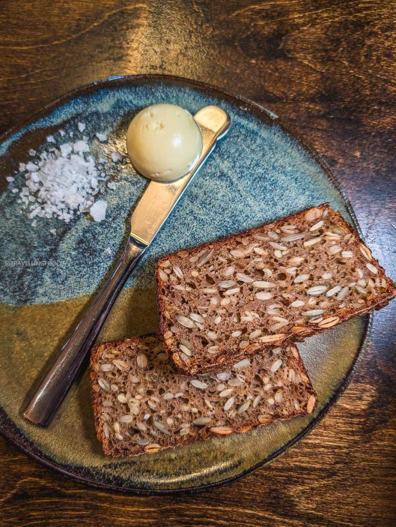 Travelling Foodie enjoying rye bread at an incredible nine-course tasting menu at Perch in Ottawa.