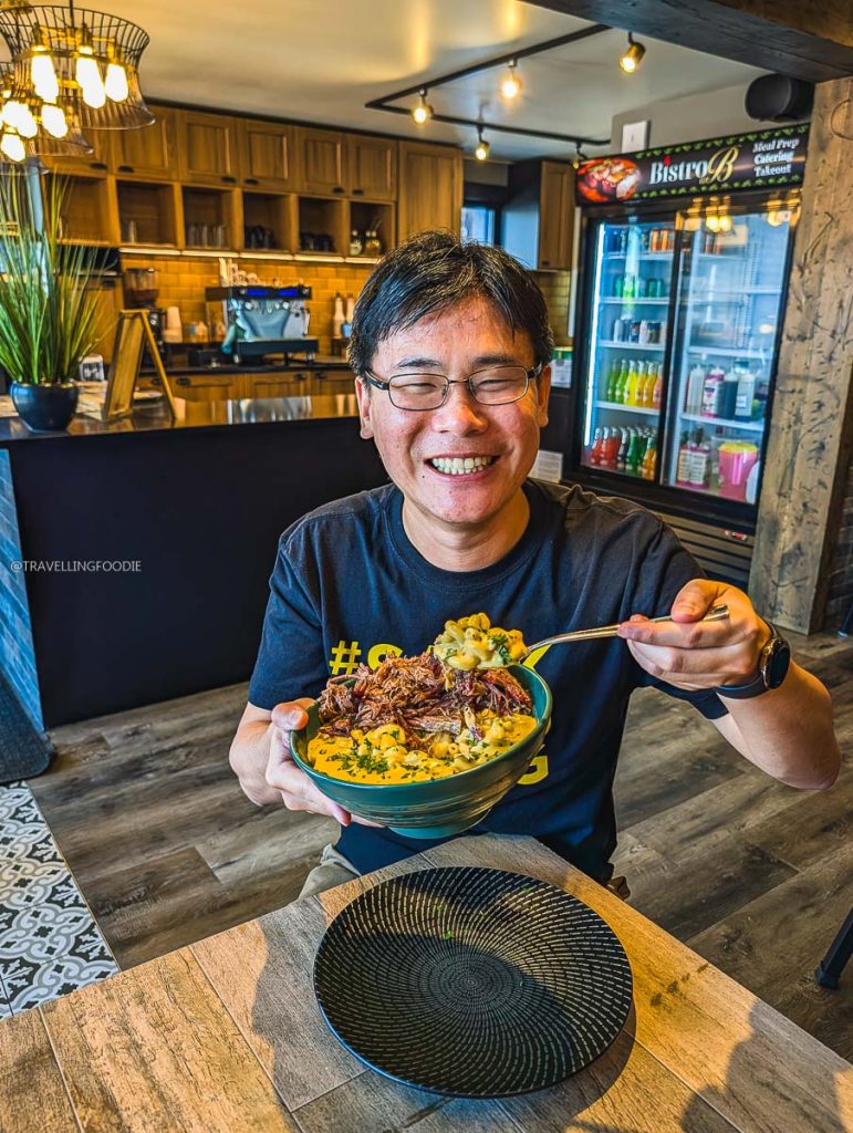 Travelling Foodie Raymond Cua taking a bite of Brisket Mac and Cheese at Bistro on B, a top Saskatoon local restaurant.