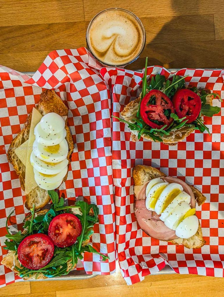 Breakfast croissants with eggs and cortado coffee at Christies Il Secondo, a cozy Saskatoon cafe.