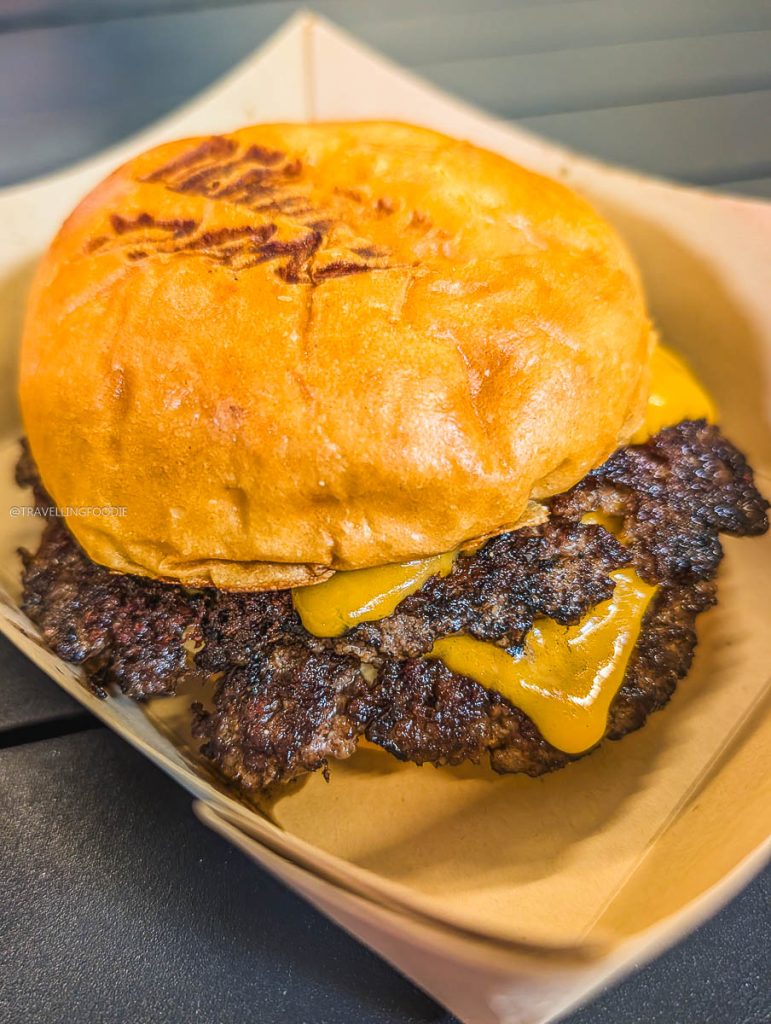 Close up of the cheesy Animal Smash Burger from Deadly Dan's, one of the best local restaurants in Saskatoon.