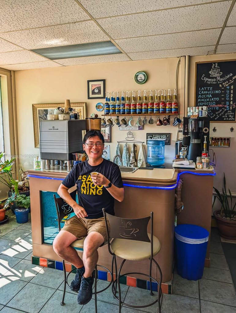Travelling Foodie Raymond Cua enjoying an espresso shot at Espresso Macchina, showing exactly where locals drink coffee in Saskatoon.