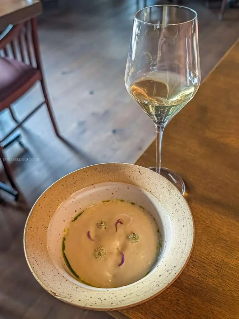 Green peas in a rich pork jus with ajo blanco sauce at a Lanaudiere-Mauricie Michelin restaurant
