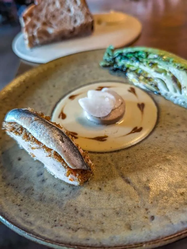 Confited capon with grilled lettuce and sourdough at a Michelin star restaurant in Authentic Quebec