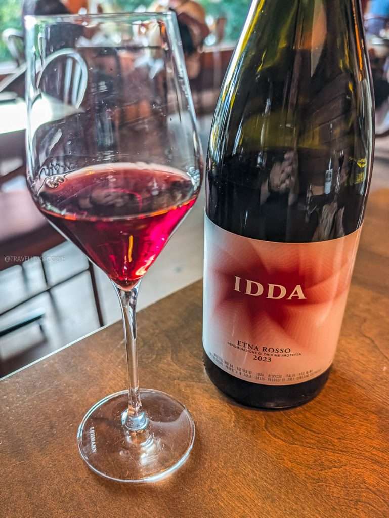 A glass of IDDA Etna Rosso red wine poured during a luxury culinary road trip in Authentic Quebec