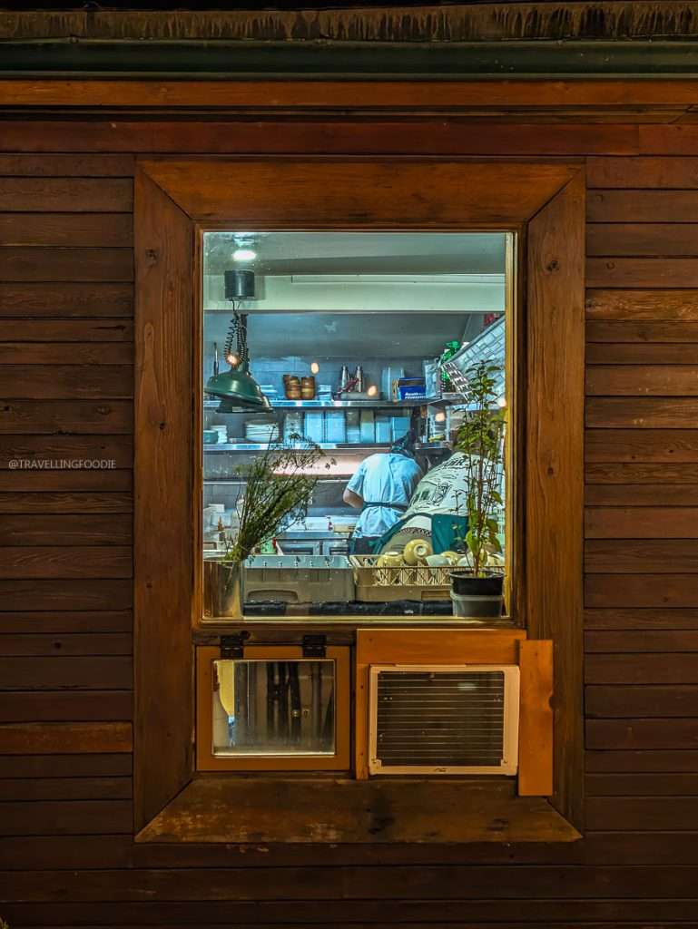 A peek into the glowing kitchen window of Auberge Saint-Mathieu at night in the Mauricie region