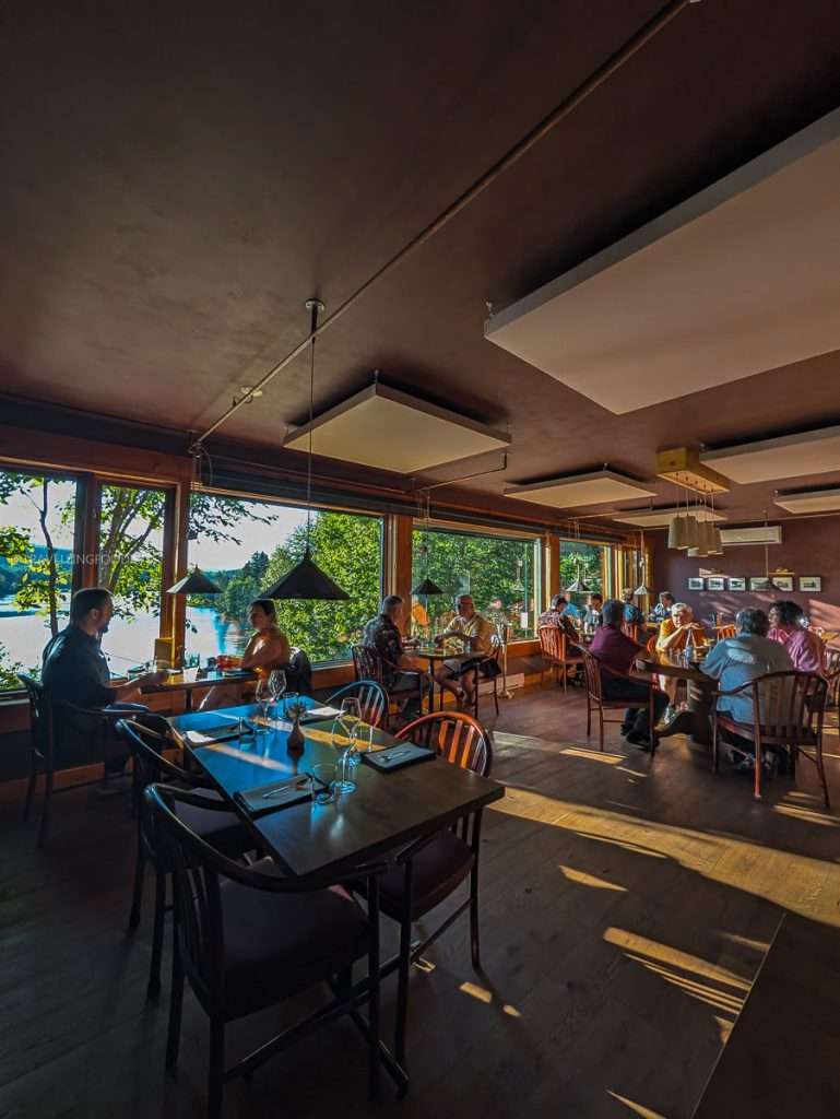 Guests enjoying a Michelin fine dining experience with beautiful lake views inside Auberge Saint-Mathieu.