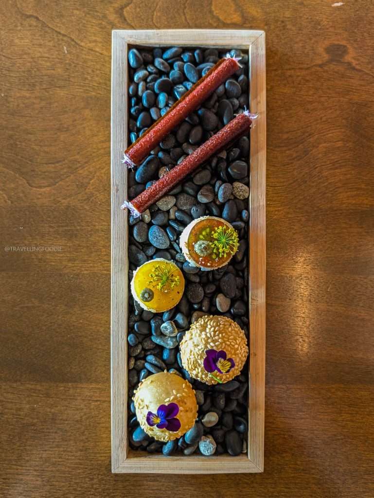 Three creative amuse-bouches served on river stones at Auberge Saint-Mathieu in Authentic Quebec