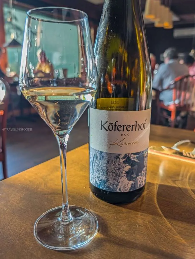 A glass of Kofererhof Kerner white wine paired with our Michelin tasting menu in Authentic Quebec