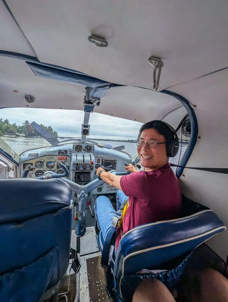 Travelling Foodie Raymond Cua smiling in the cockpit during a Bel Air Aviation seaplane tour over the Mauricie region