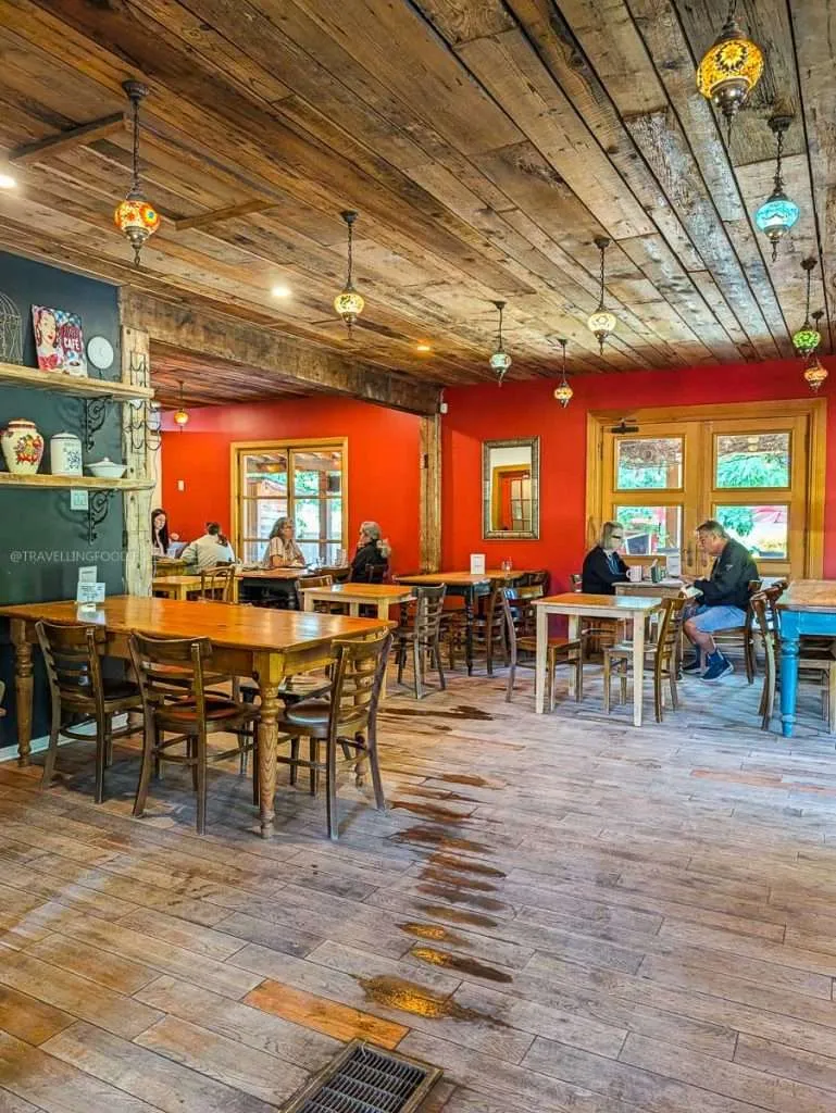 Cozy rustic dining room interior with wooden ceilings and red walls at Biscotti & Cie, a popular Chelsea cafe.