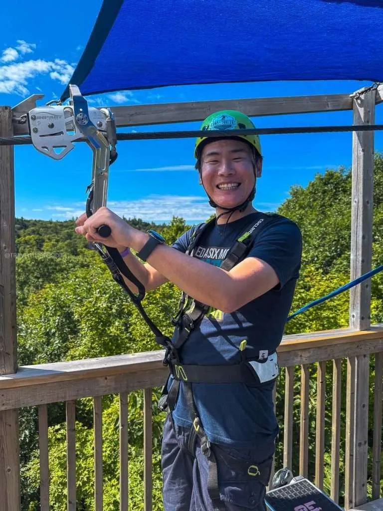 Raymond Cua wearing a helmet and harness preparing for the Peak to Peak zipline at Camp Fortune in Chelsea, Quebec.