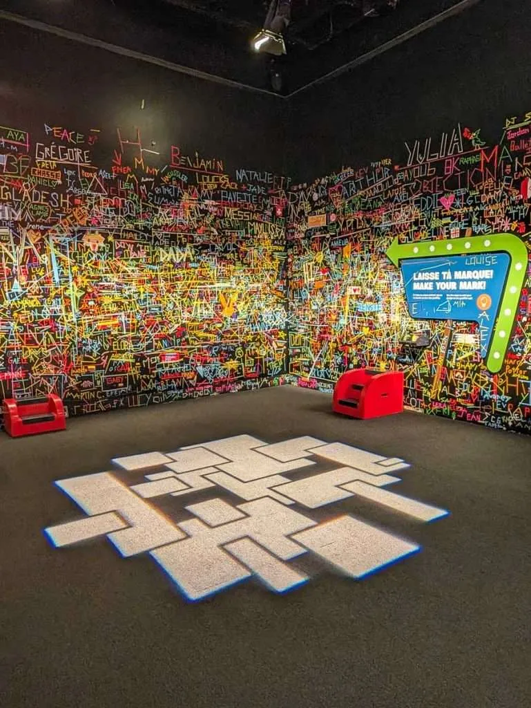 A colorful neon graffiti interactive wall exhibit inside the Canadian Museum of History in Gatineau.
