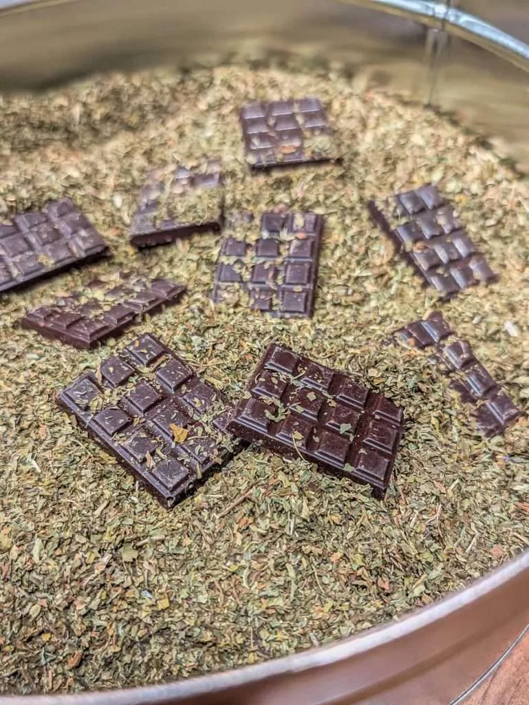 Dark chocolate squares aging in a tin of mint for the unique Cave d'Affinage technique at ChocoMotive in Montebello.