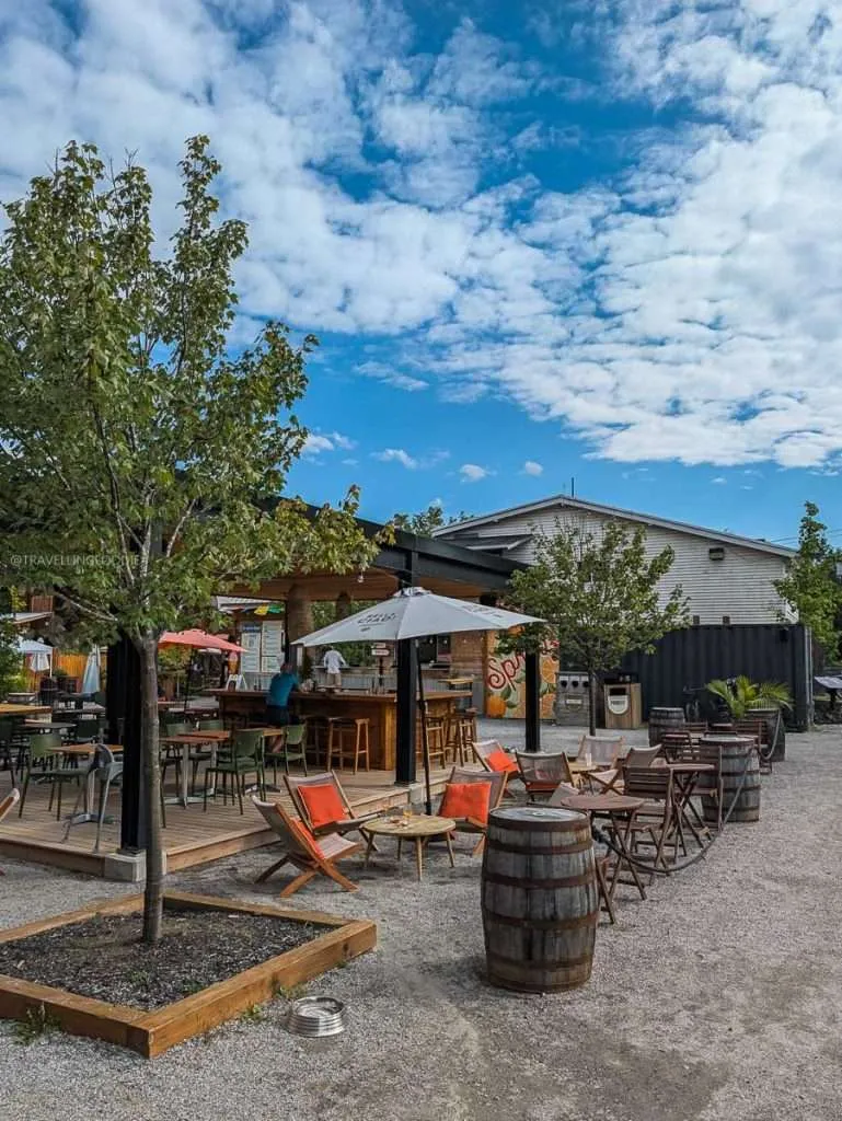 The Terrasse du Square outdoor bar patio with wooden barrels and seating outside Distillerie du Square in Chelsea.