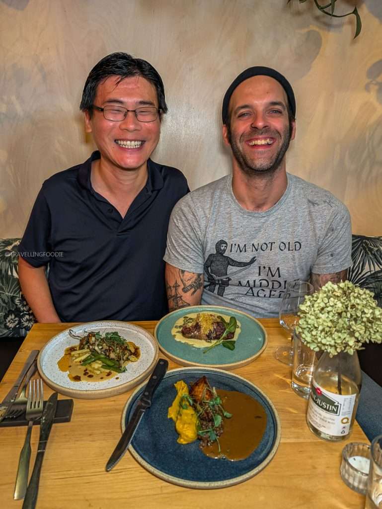 Travelling Foodie Raymond Cua and Chef Simon Lemire smiling with a table of fantastic Michelin recommended dishes at Épi, buvette de quartier in Authentic Quebec