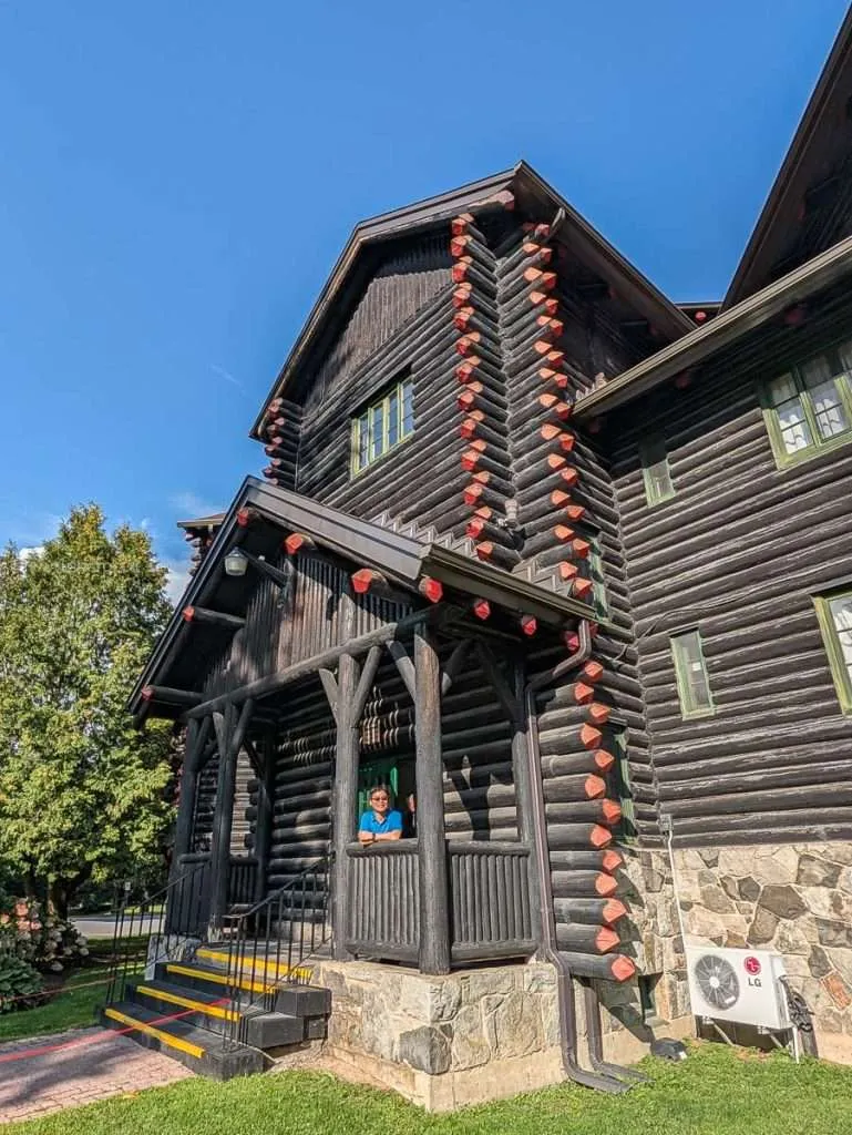 Travelling Foodie Raymond Cua standing at the cedar log exterior entrance of Fairmont Le Chateau Montebello.