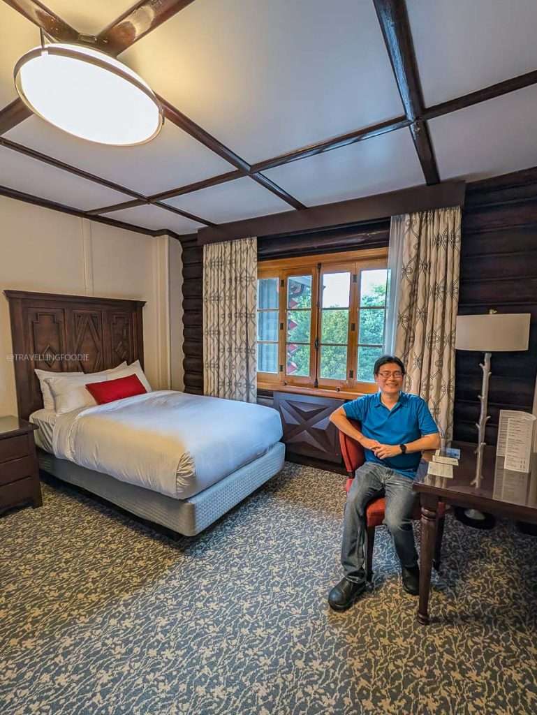 Raymond Cua relaxing inside a rustic log cabin guest room at Fairmont Le Chateau Montebello.