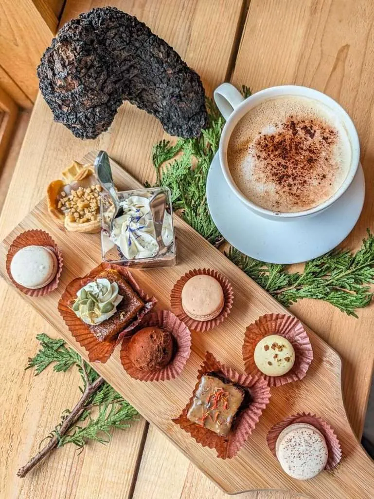 A chaga latte and tray of Indigenous pastries including macarons at Kisisam Patisserie.