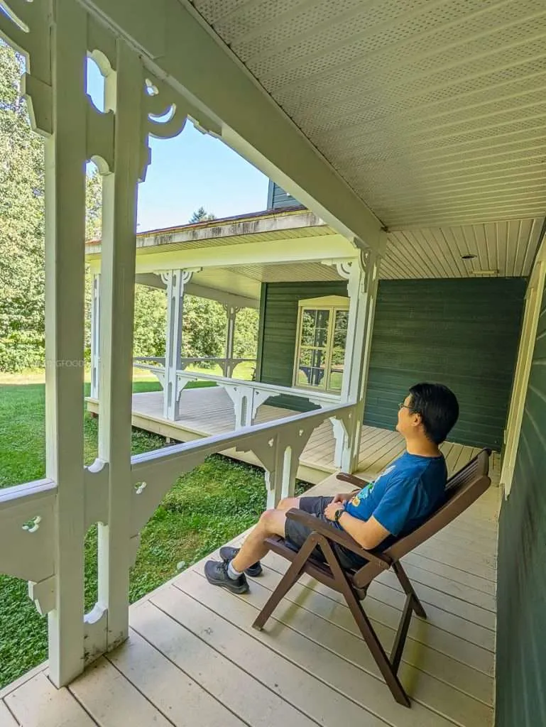 Travelling Foodie Raymond Cua relaxing on the private wooden porch of my Ambiance Room at Le Baluchon during our luxury Quebec road trip
