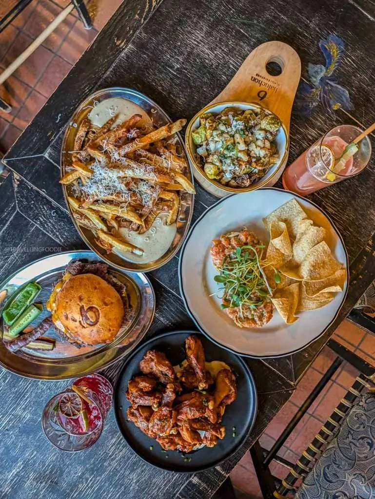 A massive lunch spread of truffle fries, tartare, and a smash burger at the Le Baluchon Eco-Cafe.