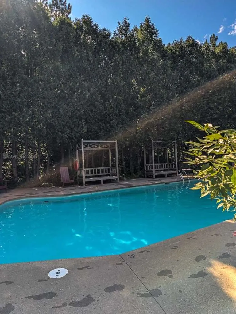 The beautiful outdoor swimming pool surrounded by green trees at Le Baluchon eco-resort in Lanaudiere-Mauricie