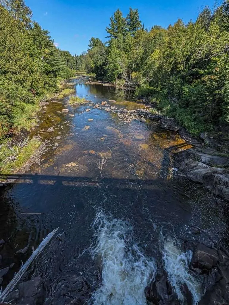 A scenic view of the rushing river and nature trails at Le Baluchon in the Lanaudiere-Mauricie region