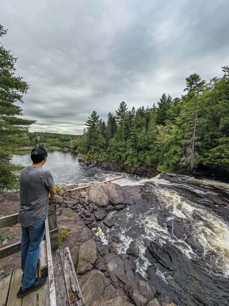Raymond Cua admiring the breathtaking Trembles Falls from a wooden boardwalk at Le Baluchon eco-resort in Quebec