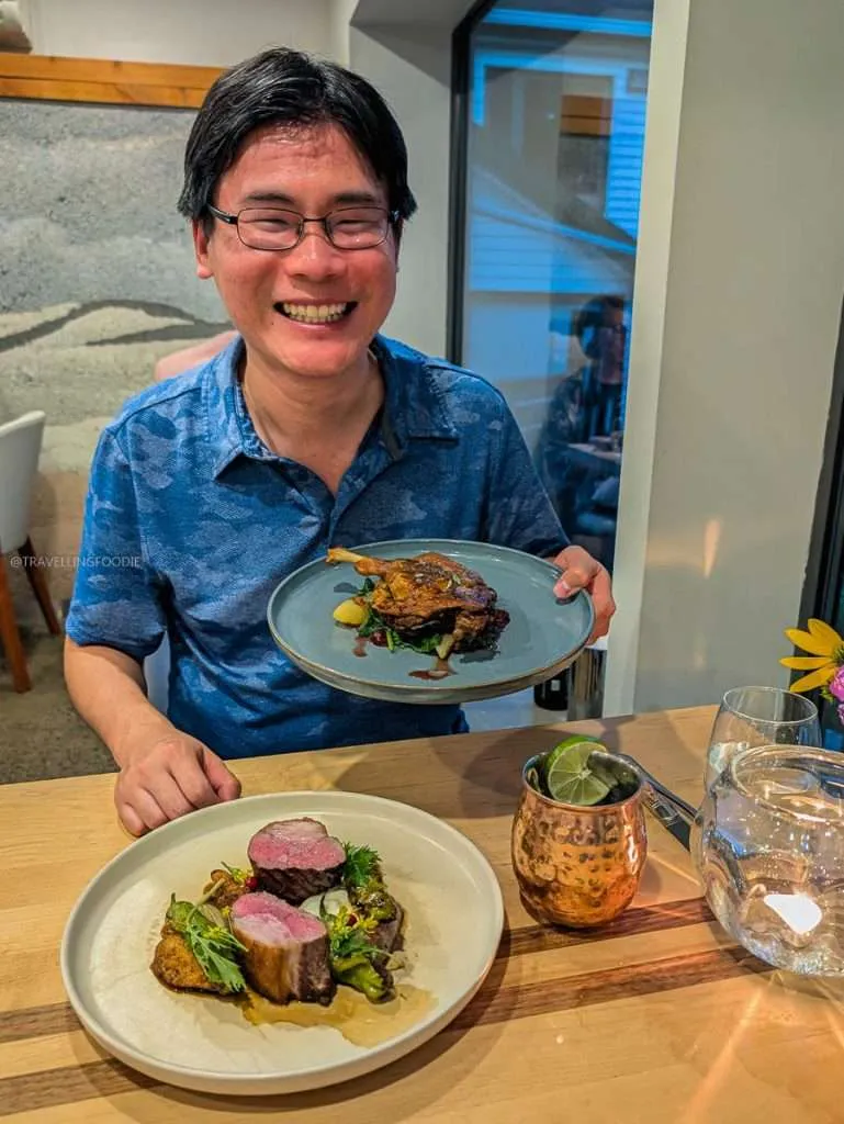 Raymond Cua holding the famous Quebec Duck Confit at Les Fougeres, one of the best places to eat in Chelsea Quebec.
